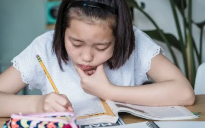 Anak sedang belajar dengan tekun di meja belajar yang rapi sebagai tips mengatasi anak susah fokus belajar
