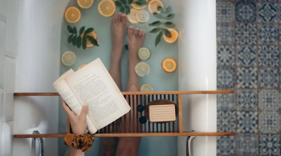 Wanita santai menikmati waktu self care murah meriah di rumah dengan membaca buku